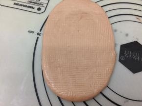 醒发好的面团，拿一个面团出来，用擀面杖擀成舌形状，