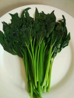 焯熟的红薯叶捞起装盘，淋上海鲜酱油