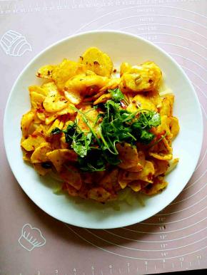 把炸好的土豆片铺在之前炒好的圆葱丝上，把香菜段放在最上面，上桌拌匀就可以吃了。