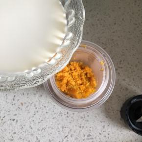 把蒸熟的南瓜倒入料理机内，倒入碾碎的咸鸭蛋黄，倒入牛奶