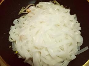 将冷水冲洗过的河粉抓入锅中。