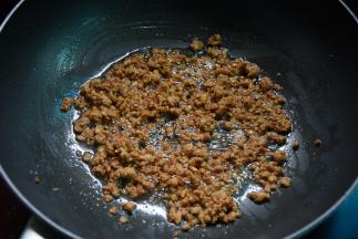 锅中加少许油烧热，倒入肉末快速炒散，炒到肉变色肉粒酥干