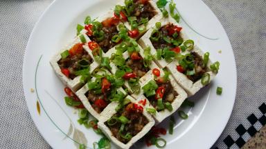 18．将豆腐盒小心的移到盘中，上面用尖椒碎和葱花进行点缀。