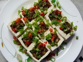 18．将豆腐盒小心的移到盘中，上面用尖椒碎和葱花进行点缀。