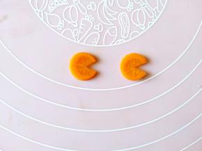 另外的两片胡萝卜用裱花嘴刻成圆形，再分别切出一个缺口