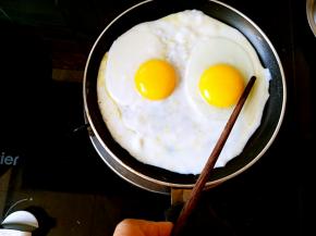 开小火，在筷子的辅助下把蛋黄固定一会儿，可以两只手一起的，我是因为拍照不方便，所以是用的一只手。就这样静止一会儿蛋黄就不会再移动了。