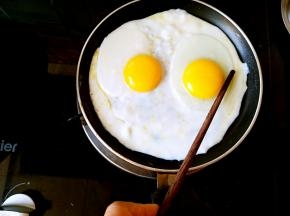 开小火，在筷子的辅助下把蛋黄固定一会儿，可以两只手一起的，我是因为拍照不方便，所以是用的一只手。就这样静止一会儿蛋黄就不会再移动了。