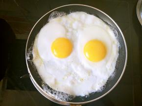 待蛋清全部凝固之后，就要不时的用小勺子往锅边很蛋黄上面淋热水，这样做的目的是确保蛋白不焦和蛋黄不变白。