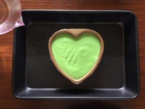 将心型模具外部包上锡纸，倒入面糊；放入烤盘，在烤盘中加入半盘水