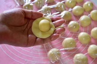 取一份水油皮，按扁，包入一份油酥，收口，将收口捏紧后滚圆即成酥皮面团