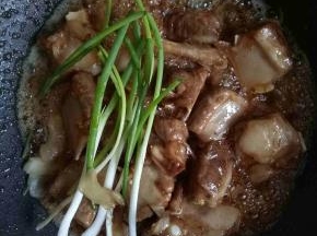 加入姜片，葱段继续炒香