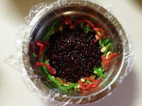 再在碗周围铺上红绿丝、瓜子仁和葡萄干