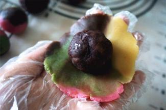 将桃山皮压扁，包入红豆馅。