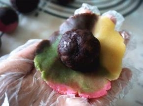 将桃山皮压扁，包入红豆馅。