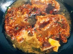 煎大排的油入锅，5成热后放入姜片、葱粒、冰糖、炒出葱油香放入大排，倒入热水至没过大排（约5—8cm）加入八角、老抽、黄酒，盖锅盖中火炖煮半小时，视汤汁变浓稠，收至约原来汤的2/3。