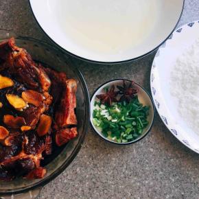 大排放盘子里入两汤勺黄酒、两汤勺老抽、姜片、一小勺盐，用手将其抓均匀～然后腌制一小时