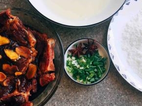 大排放盘子里入两汤勺黄酒、两汤勺老抽、姜片、一小勺盐，用手将其抓均匀～然后腌制一小时