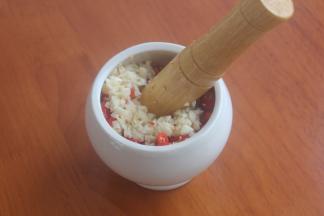 全部切好之后放入捣蒜缸里，大蒜随之铺上