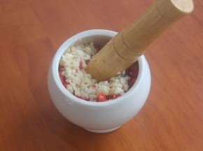 全部切好之后放入捣蒜缸里，大蒜随之铺上