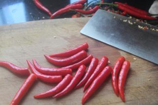 水分干之后切掉辣椒蒂，然后一个辣椒大概切三刀，大蒜随便切两下