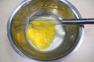 把5个鸡蛋的鸡清和蛋黄分开备用，蛋黄加入油糖里搅拌均匀。