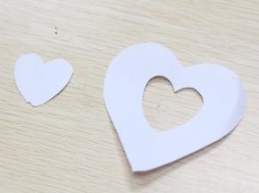 冷藏好的慕斯脱膜后，用纸剪成心形的状