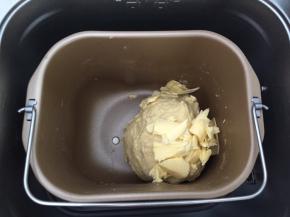 将黄油软化，放入揉好的面团，继续揉面40分钟