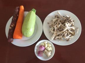 准备食材：西葫芦、腊肠、蟹味菇、胡萝卜、葱、姜、蒜