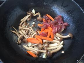 翻炒出香时放入胡萝卜条和腊肠