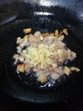 7.下瘦肉炒至变颜色，下蒜蓉炒出香味。