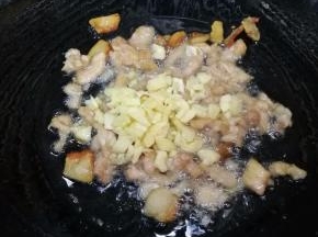 7.下瘦肉炒至变颜色，下蒜蓉炒出香味。