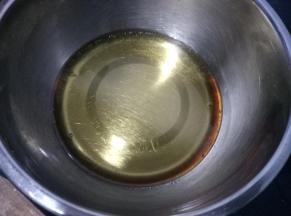 干净的盆中，放入 40克花生油，115克转化糖浆和2克枧水，搅匀，糖浆和油乳化好