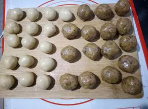 静置好的金沙肉松香肠馅分成每个30克，一共是16个，盖保鲜膜以防止表面风干影响口感。静置好的面团每个20克，也分成16份。