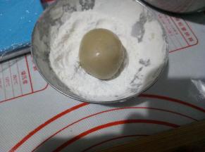 利用左手虎口慢慢往上推，把内馅包住，然后放面粉里滚一下，再去掉多余的面粉。