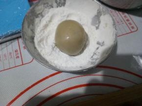 利用左手虎口慢慢往上推，把内馅包住，然后放面粉里滚一下，再去掉多余的面粉。