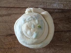 再把卷好的面团如图象蛇一样盘起来，拧成圆面团