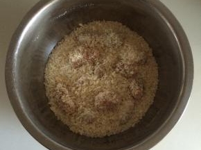 把鸡肉放入面包屑中，摇晃盛器，让鸡肉快速均匀的裹上面包屑