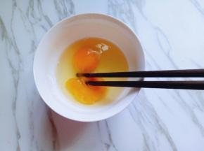 鸡蛋打在碗里，用筷子打散。