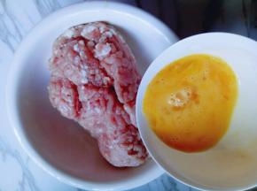 将打散的鸡蛋液倒入肉糜容器中。