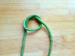 取一根长豇豆，编制花环。