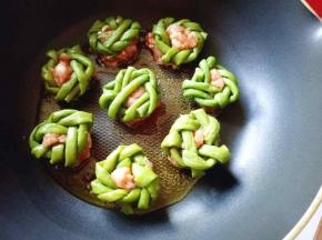 将编制好的花环酿肉糜放入平底锅中。(将肉糜朝下)盖上盖子闷煎。