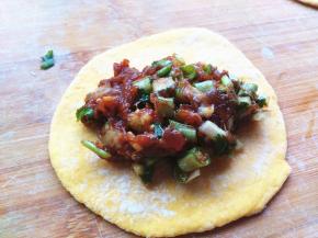 擀好的面皮，放入一勺肉馅，包好包子。