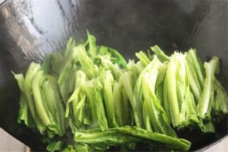 加入切好的油麦菜，这时可以看到油烟，说明油温比较高。