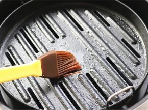 苏泊尔翻炸锅的烤篮里倒入少许油，用刷子刷开