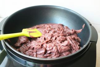 搅拌好的红豆沙倒入不粘锅里。