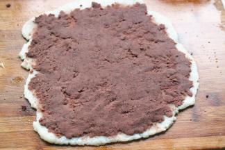 案板上抹一些油防粘，把年糕移到案板上，擀成均匀的薄片，上面抹上一层刚才炒好的豆沙，尽量抹均匀。