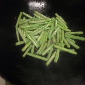把洗好的豆角倒入翻炒