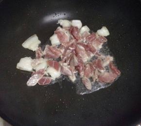 锅里倒入凉油，把切好的猪肉加入翻炒