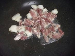 锅里倒入凉油，把切好的猪肉加入翻炒