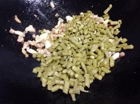 倒入酸豆角翻炒，（如过炒的过程太干的话可以加入少量水稍微让菜湿润一点）